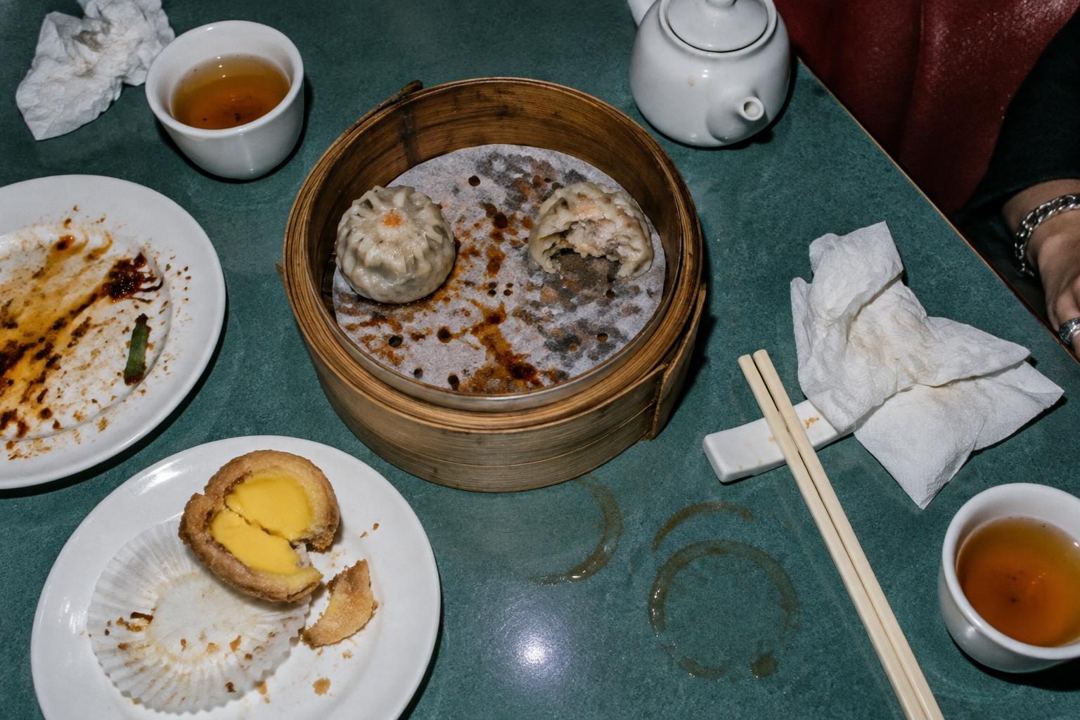 Dumplings, a broken custard tart and tea rings on a well-used dim sum table.